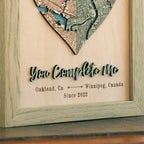 Close-up of custom heart map with raised 3D wooden lettering, personalized locations, date, and sage oak frame.