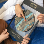 Couple holding personalized framed wooden map and pointing to home location, custom housewarming gift for new homeowners