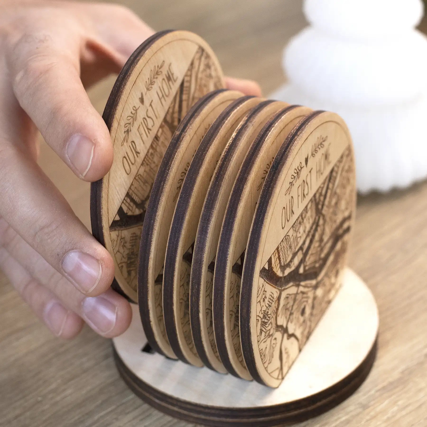 Close-up of custom wooden map coasters in holder, engraved city map coaster set with handcrafted wood finish