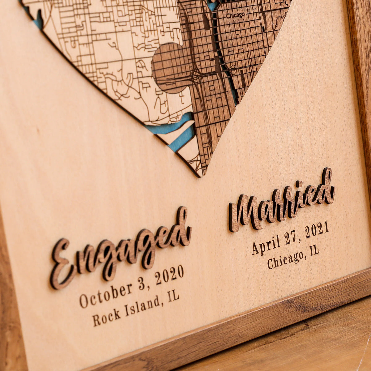 Close-up of engaged and married 3D lettering with personalized dates and locations on a custom wooden wedding map.