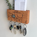 Wooden key holder with keys attached, featuring a map design on a white wall.