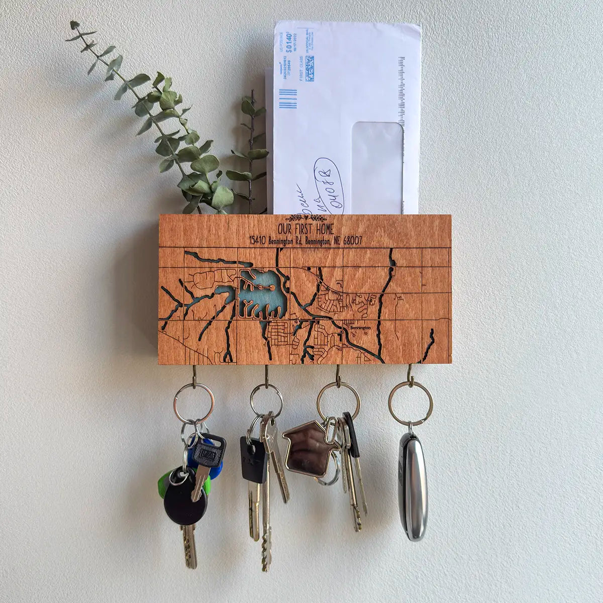 Wooden key holder with keys and a mailbox on a white wall