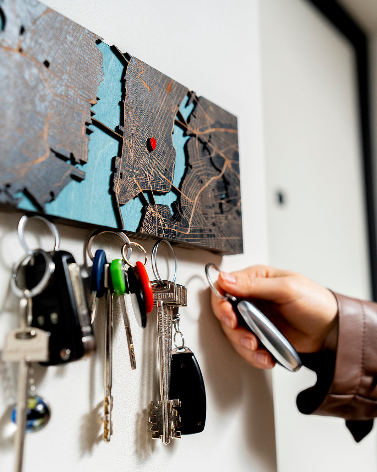 Key holder with keys attached to a wall, featuring a map design.