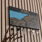 Angled view of wooden magnetic key holder for wall with custom coordinates in black finish