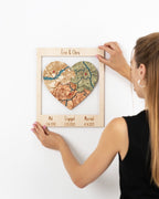 Customized heart-shaped map puzzle in a wooden frame commemorating the meeting, engagement, and marriage locations of a custom name with significant dates. custom wedding and anniversary gift