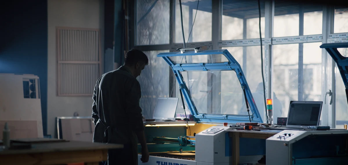 Preparing a wooden map at a laser cutting machine in the MurWoodHome workshop