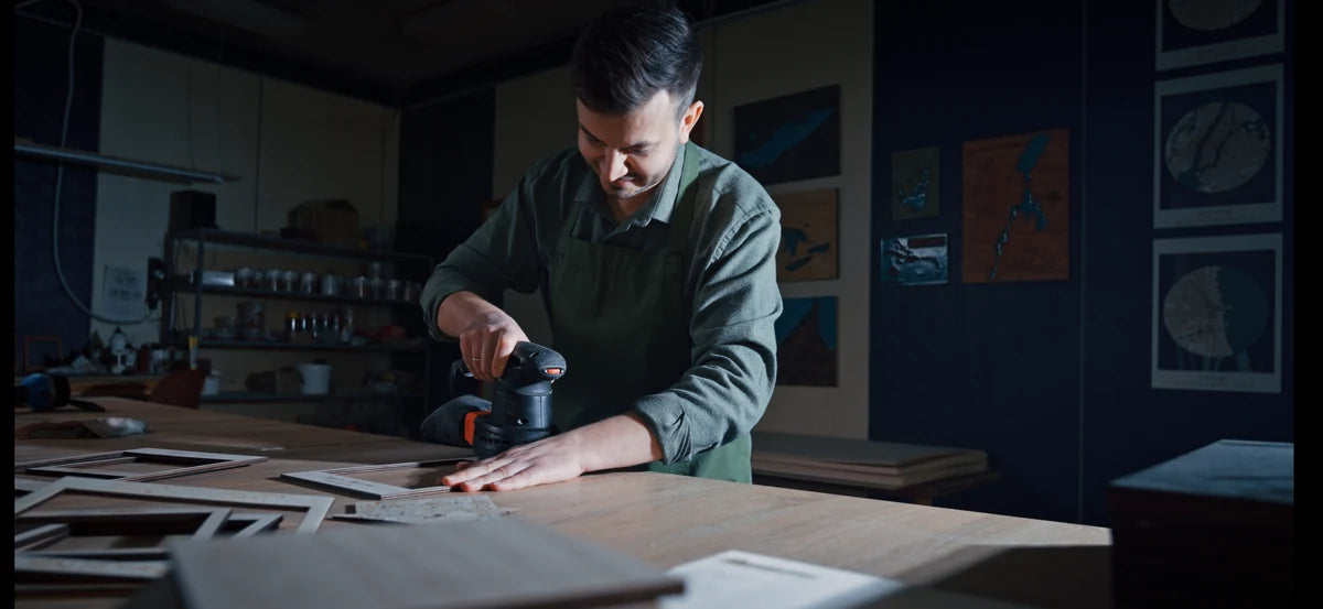 Sanding a wooden component with an orbital sander in the MurWoodHome workshop