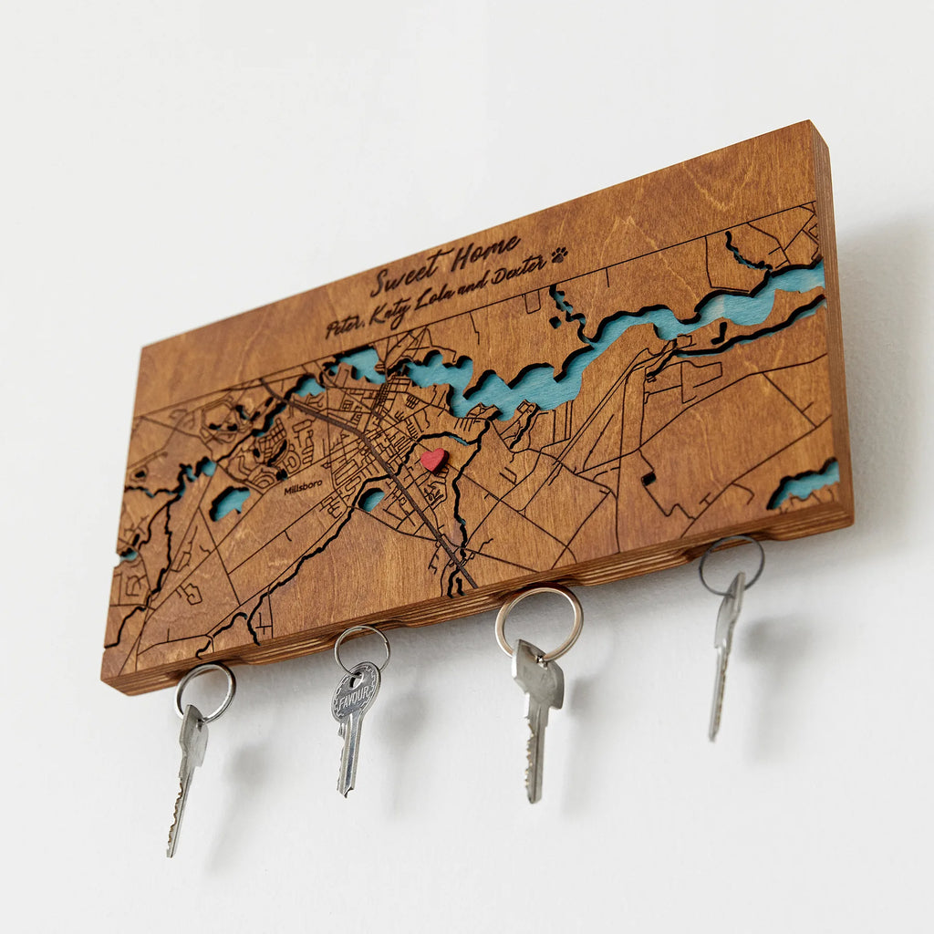 Personalized map key holder for wall shown in angled view with hanging keys