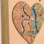 Detailed view of personalized puzzle heart map with two custom locations, red pins, blue water, and sage frame.