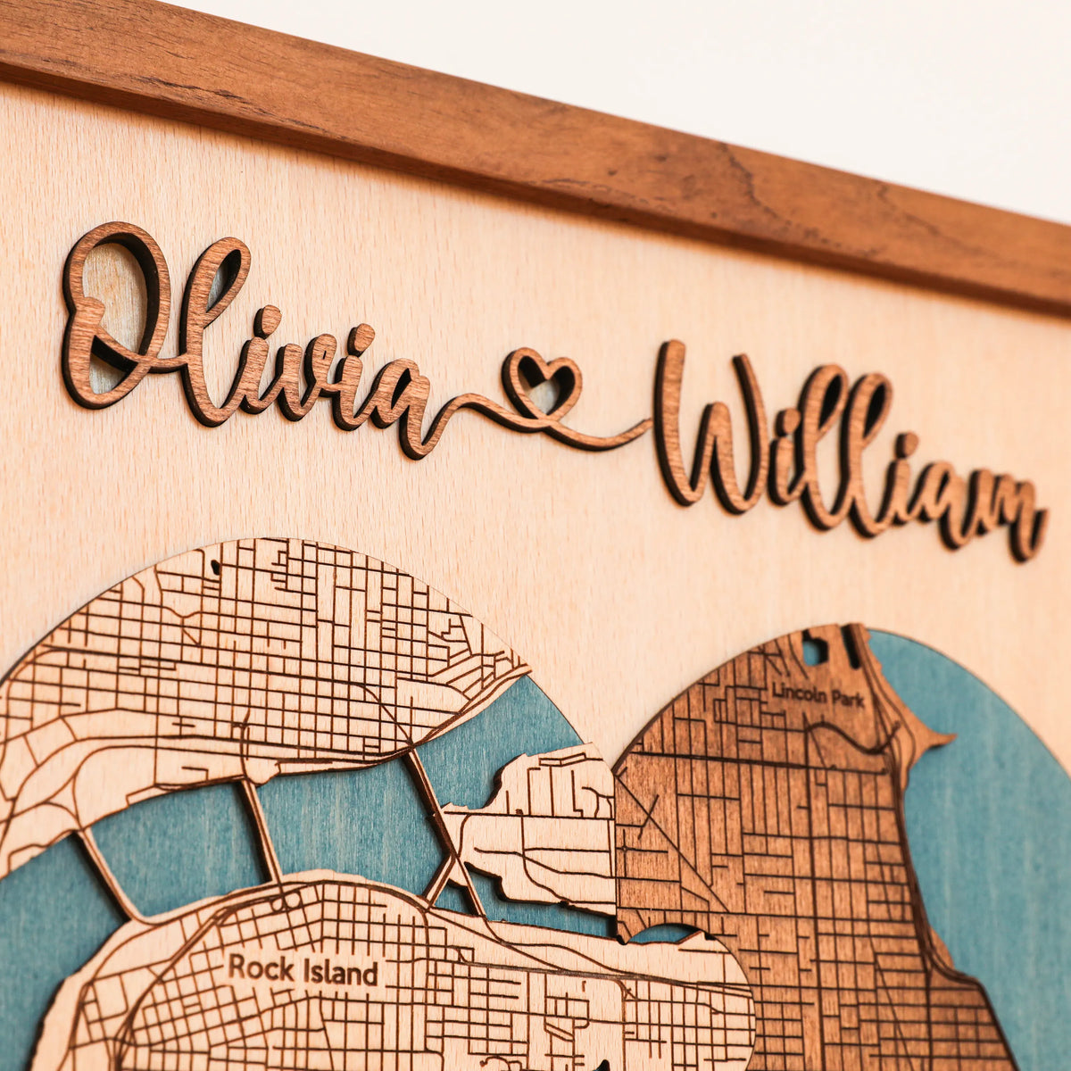 Detail of raised wooden couple names on a personalized wedding map with heart-shaped city map and natural wood finish.