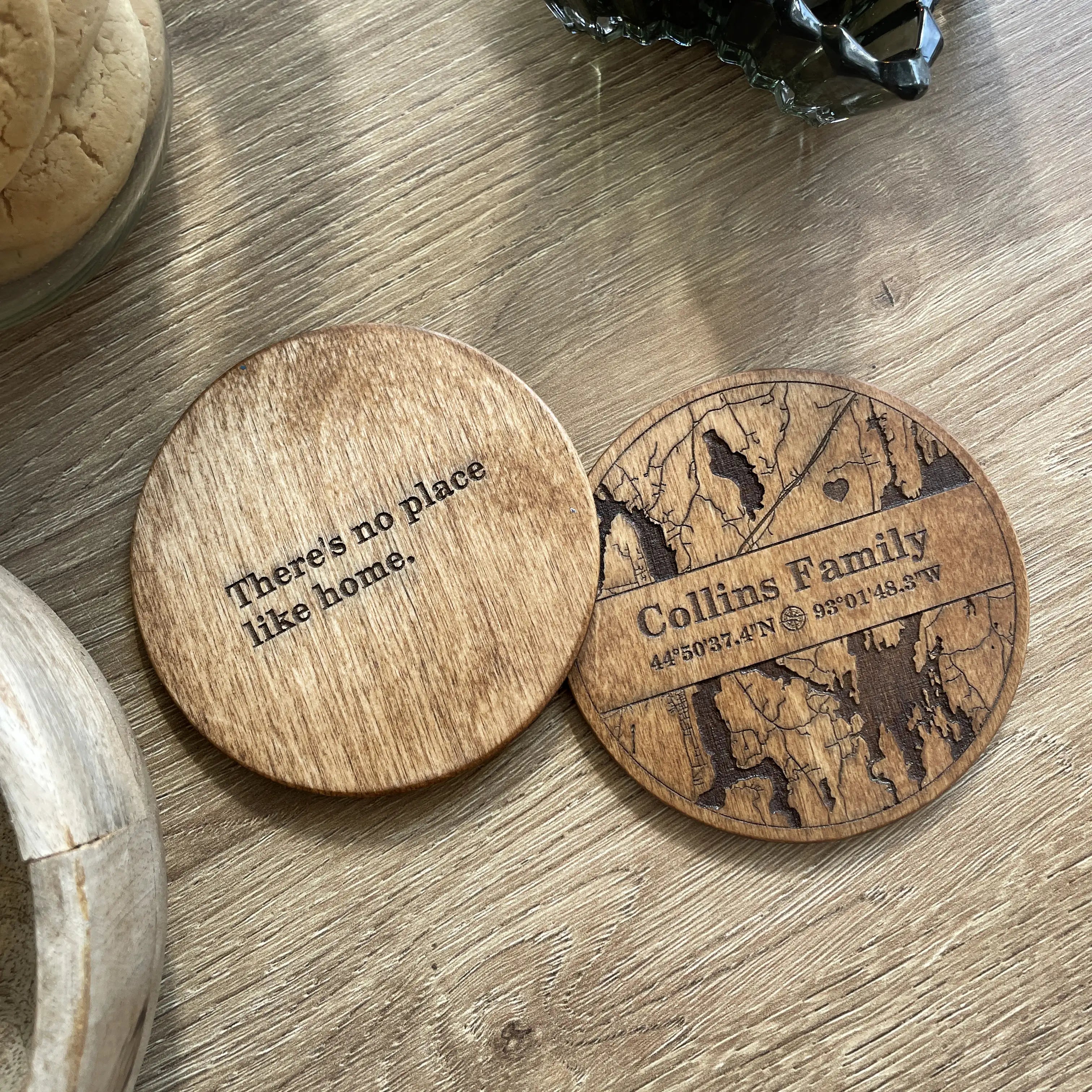 Personalized wooden coasters for housewarming showing engraved family map front and quote back side design