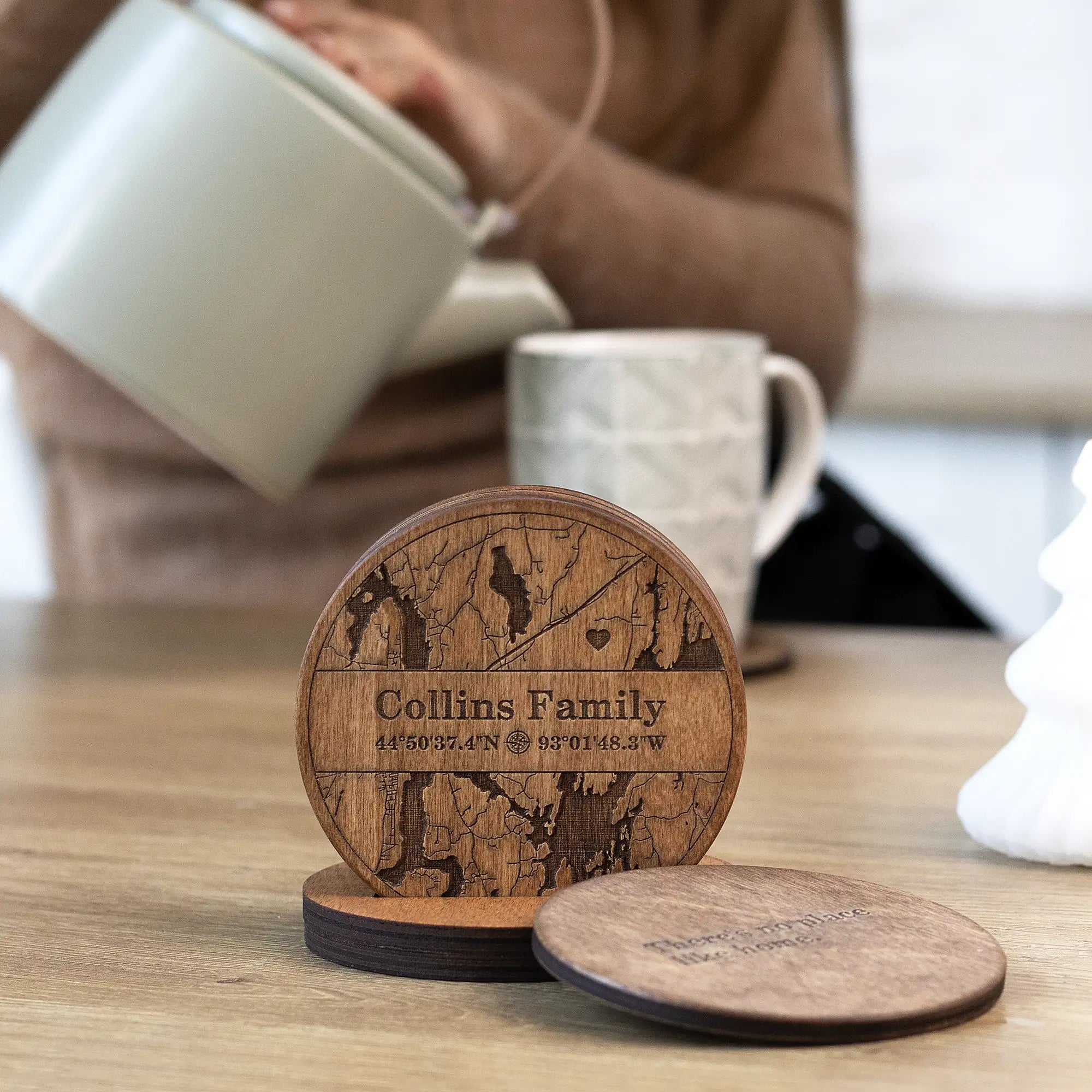 Personalized wooden coaster set for housewarming displayed on table in cozy kitchen lifestyle setting