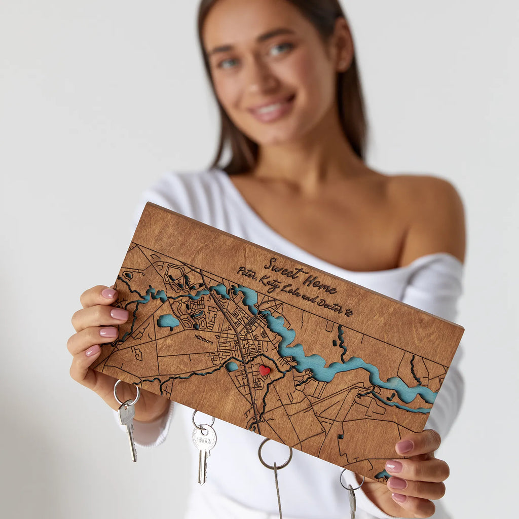 Woman holding personalized wooden key holder for wall with custom map design