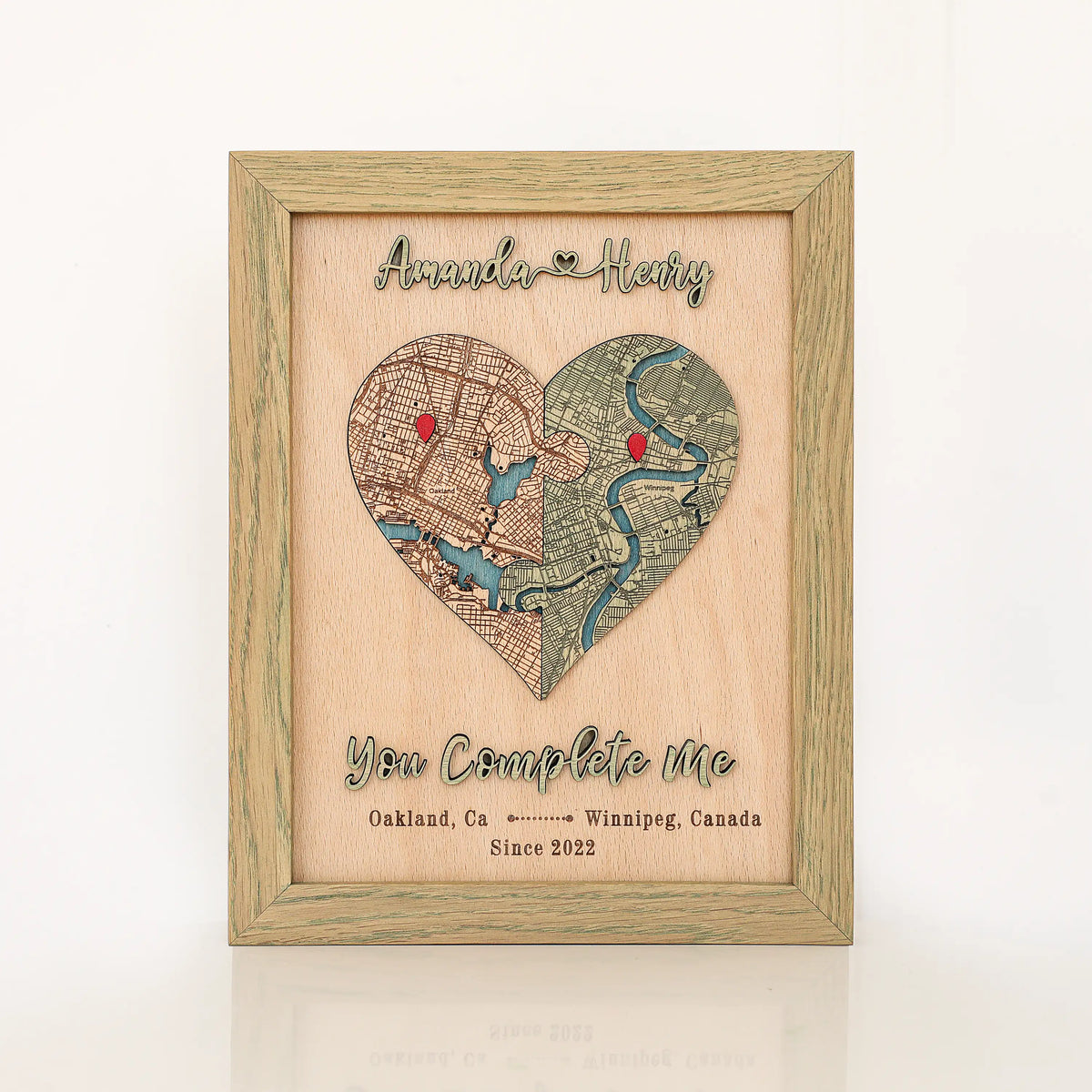 Personalized wooden love story map in sage frame with heart-shaped custom locations, raised 3D names, and romantic phrase.