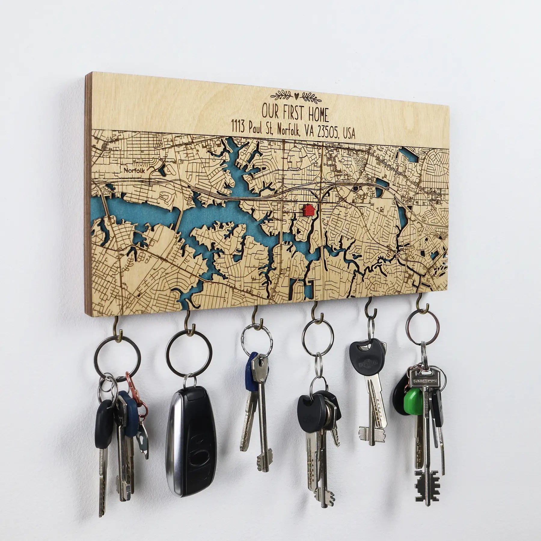 Personalized wooden wall key holder with hooks featuring a custom home map and organized key sets