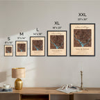 Framed maps on a wall with size labels and a lamp on a table below.