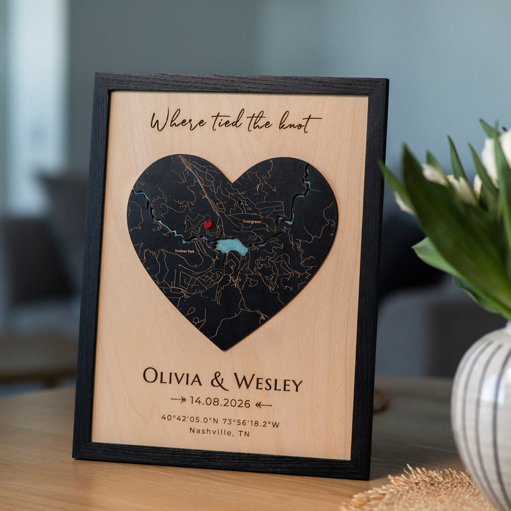 Personalized map wedding gift for couple with black oak frame, heart-shaped 3D wooden map, names, date, and red pin.