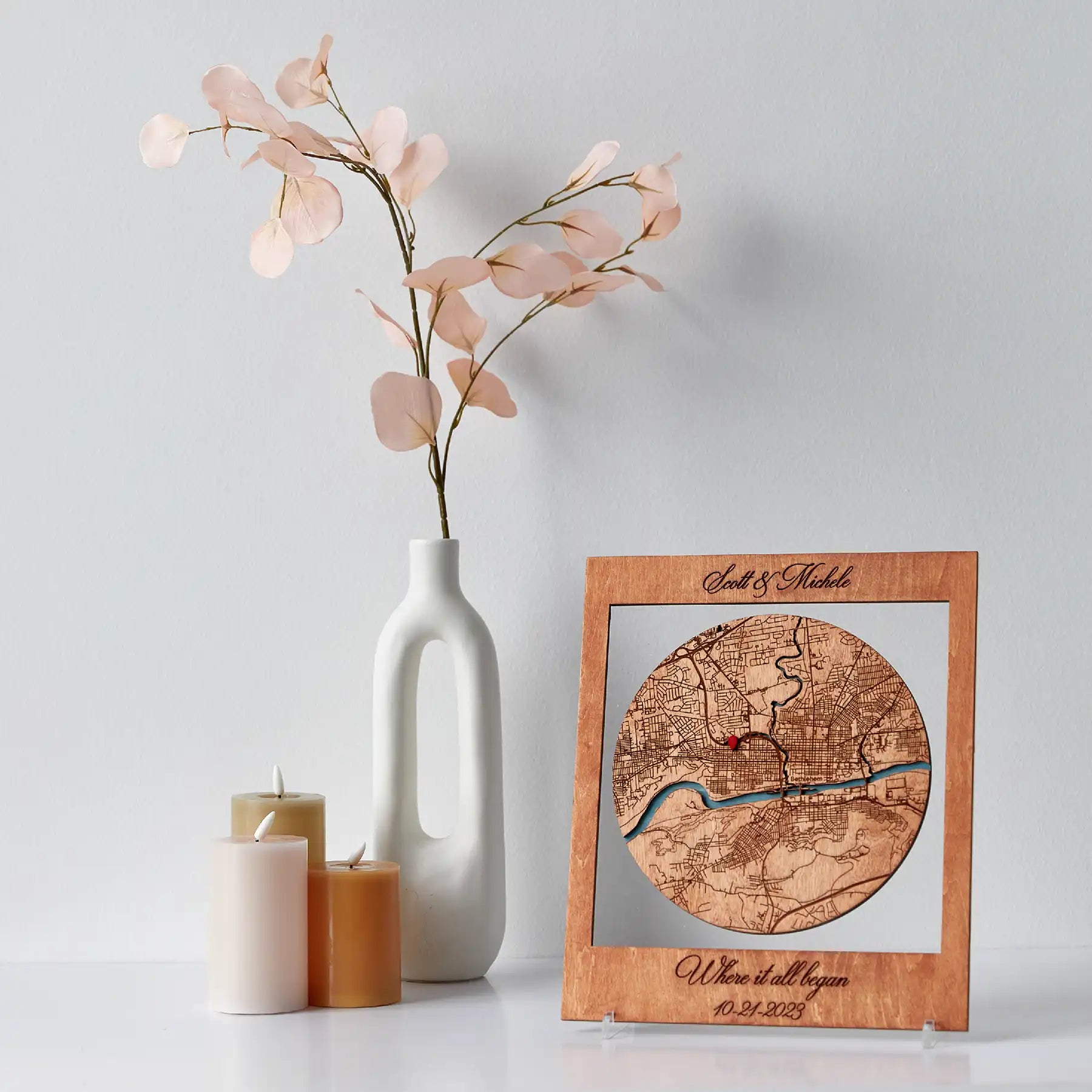 Personalized Where It All Began circle map in wooden frame displayed on shelf with vase and candles