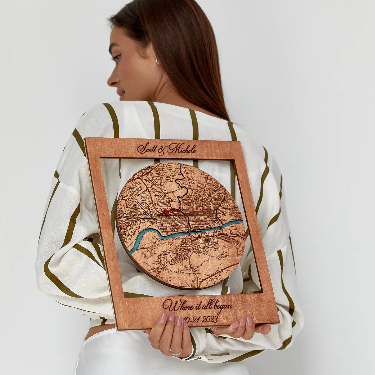 Woman holding Where We Met map gift for couples in wooden frame with custom city map