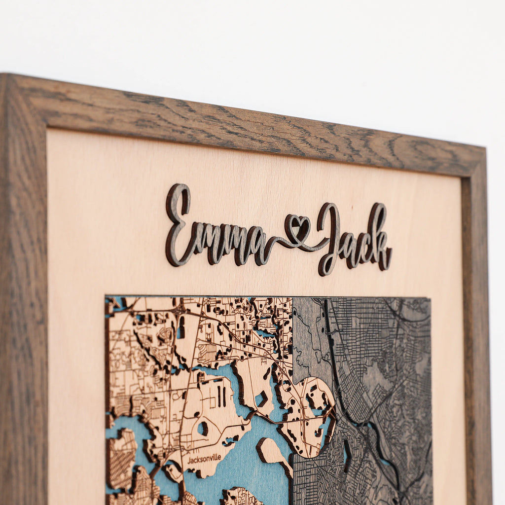 Close-up of wooden anniversary gift for him with raised 3D couple names, custom map detail, and oak frame.