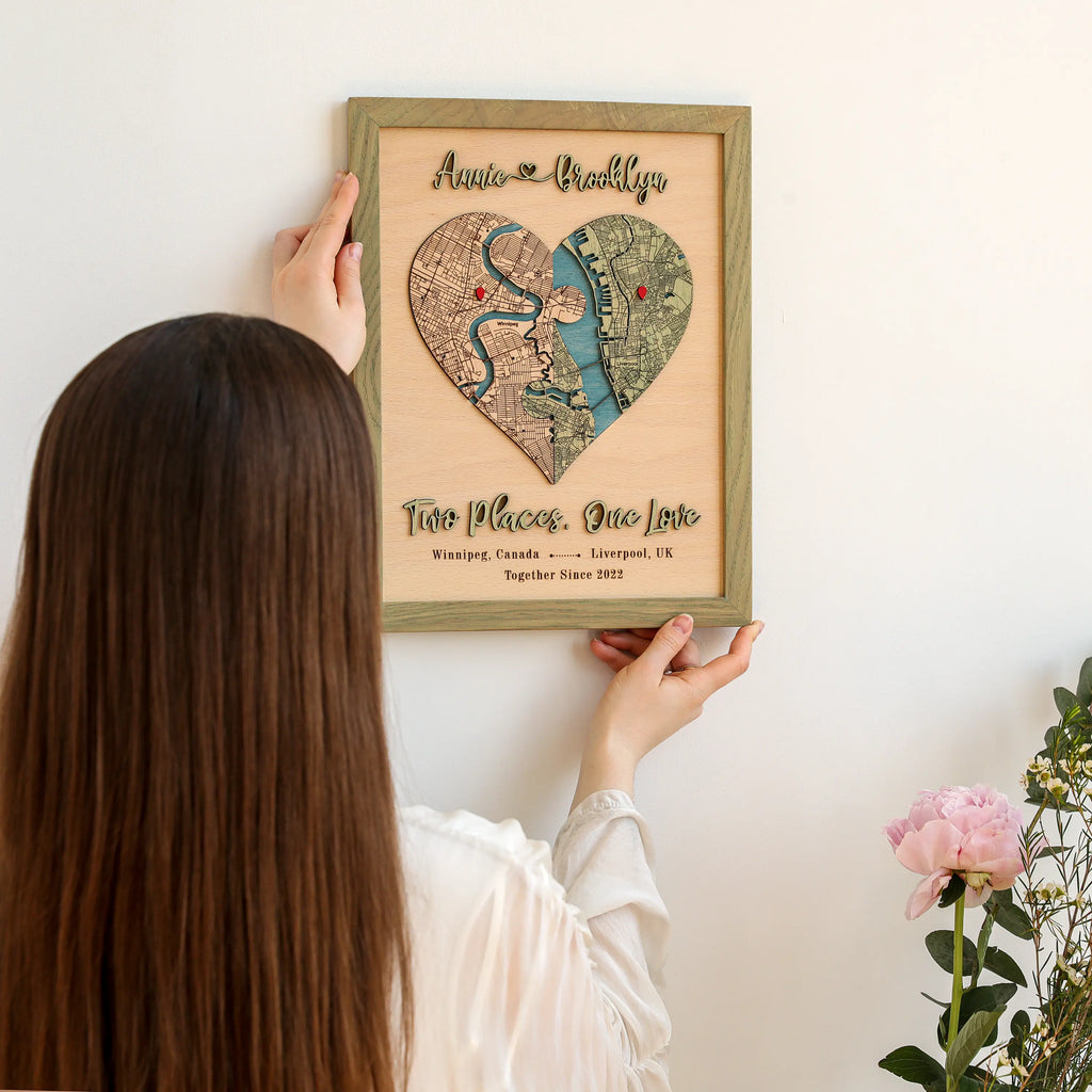 Close-up of wooden couple map with raised 3D names, puzzle heart design, and personalized two-location map.