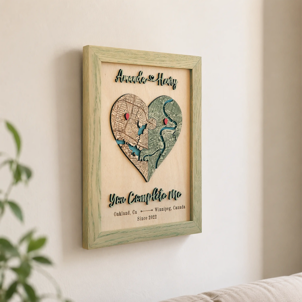 Wooden love story map wall decor in sage frame with heart-shaped custom map, red pins, names, and 3D raised phrase.