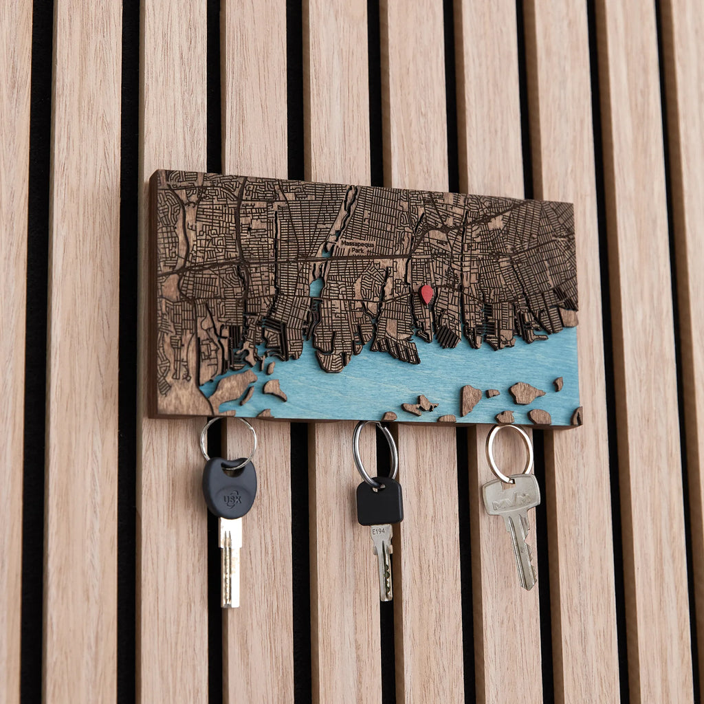 Close-up of wooden magnetic key holder for wall with custom coordinates and hanging keys